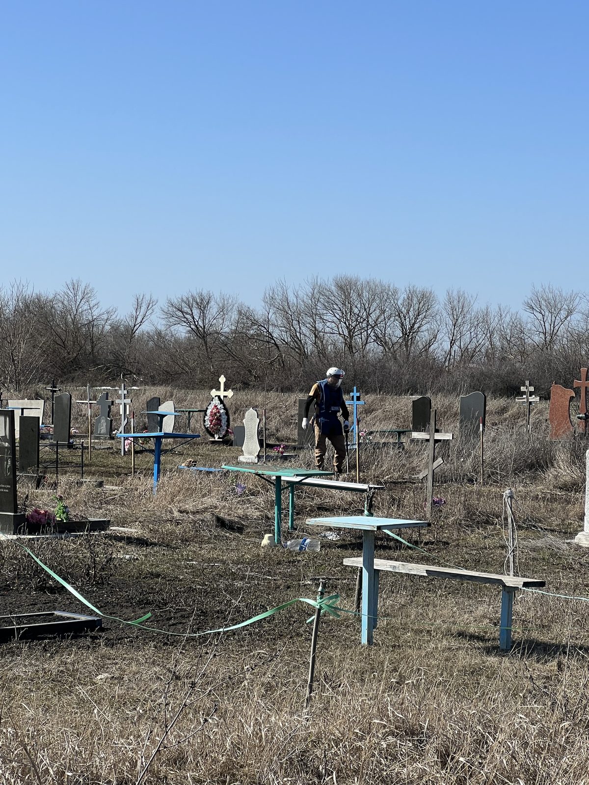 A deminer working among the graves at Ivanivka cemetery
